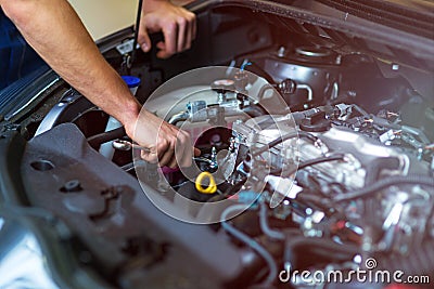 Mechanic working on car engine in auto repair shop Stock Photo