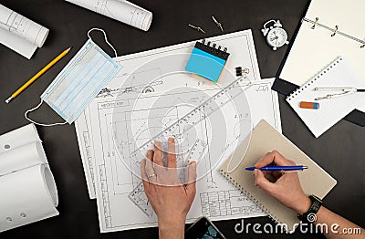 Mechanical drawing on sheets of paper. Hands on the table top view. Workflow of an architect, engineer. Write and draw Stock Photo