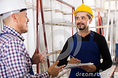 Mechanical engineer inspecting the work of labour at factory Stock Photo