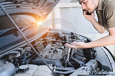 Mechanical fixing car at home. Repairing Service advice by mobile phone. Mechanic, technician man checking car engine. Car service Stock Photo