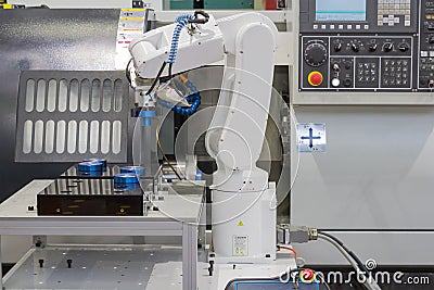 Mechanical hand robot working with CNC lathe machine Stock Photo