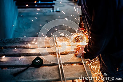 Mechanical male engineer working in factory using an angle grinder for cutting and grinding steel, iron or metal Stock Photo