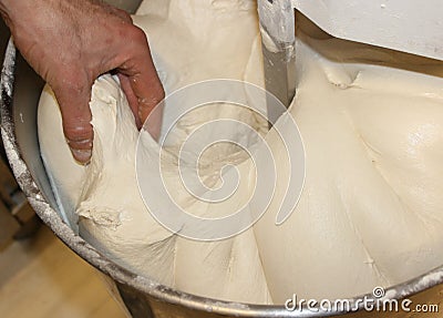 Mechanical pizza mixer at work. Raw dough in rotation. Stock Photo