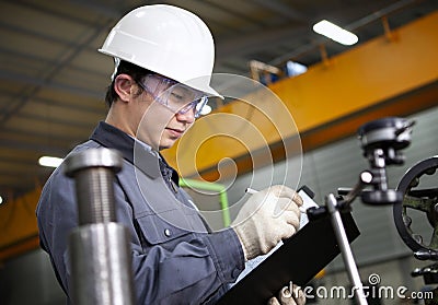 Mechanical technician writing on notepad Stock Photo