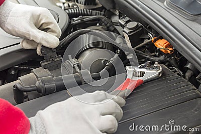 Mechanician performing maintenance on a car engine Stock Photo