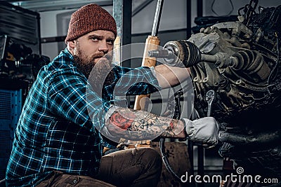 Mechanicl inspecting engine of a car in a garage. Stock Photo