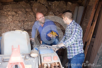 Mechanics reparing old agrimotors at farm Stock Photo