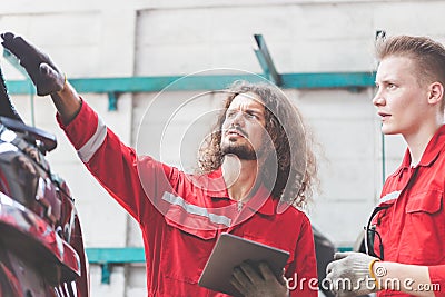 Mechanics team in uniform are working in auto service, Technician checking modern car at garage Stock Photo