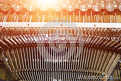 Mechanism of typesetting strikers with the English alphabet in an old retro typewriter.Solar glare Stock Photo