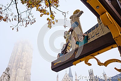 Sign leading to Sint-Rumbolds tower depicts the "maneblussers", people living in Mechelen, Belgium Editorial Stock Photo