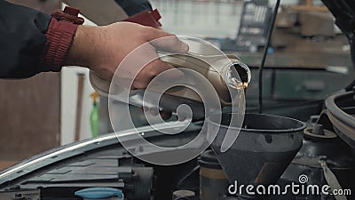 Mecánico del mantenimiento del coche que vierte el nuevo lubricante del aceite en el motor de coche Nuevo aceite sintético limpio almacen de metraje de vídeo Mecánico del mantenimiento del coche que vierte el nuevo lubricante del aceite en el motor de coche Nuevo aceite sintético limpio almacen de metraje de vídeo