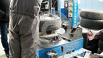Mecánico que usa la máquina de la herramienta del montaje del neumático Garaje de la reparación del coche mantenimiento del coche almacen de metraje de vídeo Mecánico que usa la máquina de la herramienta del montaje del neumático Garaje de la reparación del coche mantenimiento del coche almacen de metraje de vídeo