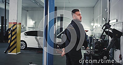 Mecânico operário de atendimento automático aproveitando o dia no trabalho enquanto conserta o carro que dançava e se movia engra filme Mecânico operário de atendimento automático aproveitando o dia no trabalho enquanto conserta o carro que dançava e se movia engra filme