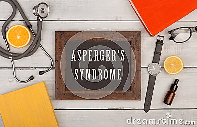 blackboard with text & x22;Asperger& x27;s syndrome& x22;, books, stethoscope, eyeglasses and watch Stock Photo