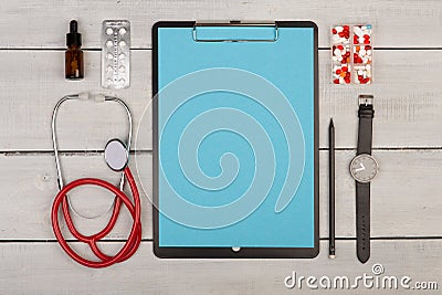 blank clipboard, pills, stethoscope and watch on wooden background Stock Photo