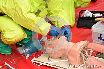 Medic in breathing apparatus and protective suit practices resuscitation. Editorial Stock Photo