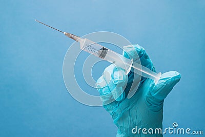 Medic holds a syringe in his hand in a medical glove. Stock Photo