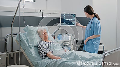 Medical assistant visiting retired patient sleeping Stock Photo