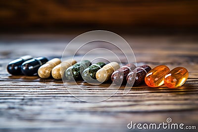 medical cannabis pills laid out in a row on a wooden surface Stock Photo