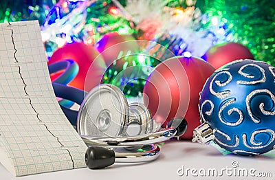Medical cardiology Christmas and New Year photo - stethoscope and electrocardiogram tape are located near balls for Christmas tree Stock Photo