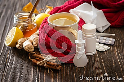 Medical care concept - ginger honey and lemon tea with drugs, pills and spray Stock Photo