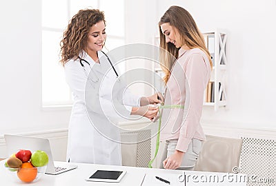 Nutritionist measuring bmi of patient in office Stock Photo