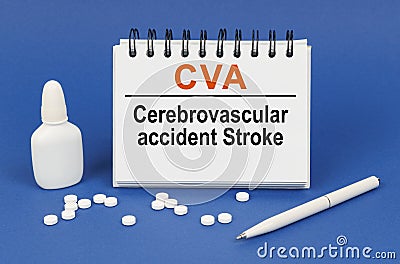 On a blue background, a pen, tablets and a notepad with the inscription - CVA Cerebrovascular accident Stroke Stock Photo