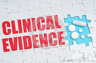 On the puzzles there is an inscription - Clinical Evidence, on a blue background pills. Stock Photo