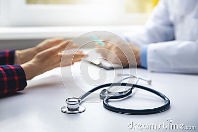 Medical consultation - doctor talking to patient in clinic office Stock Photo