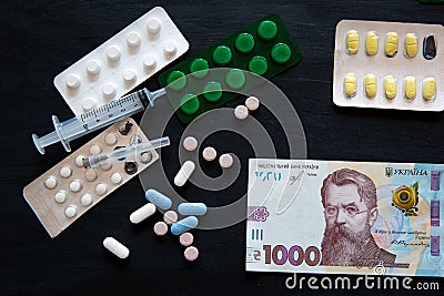 Medical costs during coronavirus crisis. Epidemic covid-19 concept in Ukraine. Hryvnia banknotes and pills Stock Photo