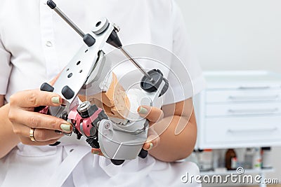 Dentist holding dental articulator with dental gypsum prosthesis model in dental laboratory Stock Photo