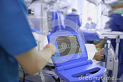 Medical doctor adjusting ECG monitor of comatose patient in the Stock Photo