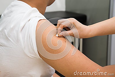 Medical doctor swap arm of patient with alcohol before vaccination Stock Photo