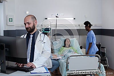 Medical doctor using personal computer to complete patient admission chart Stock Photo