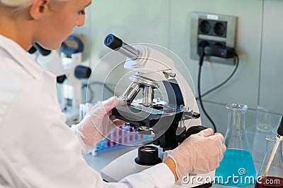 Medical doctor working in research lab. Science assistant making experiments. Laboratory tools: microscope, test tubes Stock Photo