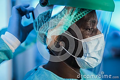Medical doctors at work inside hospital during coronavirus outbreak - Focus on african man eye Stock Photo