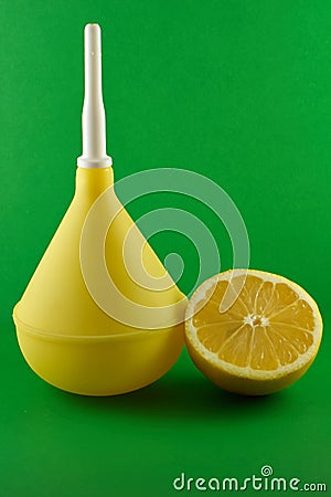Medical enema with lemon on green Stock Photo
