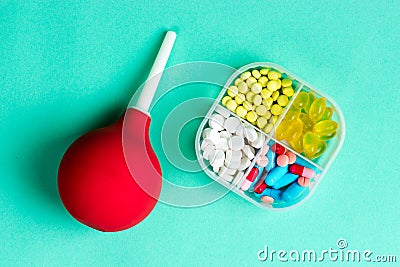 Medical enema and pill box with pills, pharmaceutical tablets, medical supplies. View from above. Stock Photo