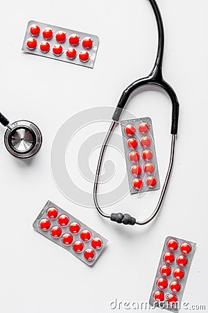 Medical equipment with stethoscope and pills in doctor`s office on white desk background top view Stock Photo