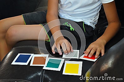 A medical examination by a psychologist. Guessing the color of the card. A child with unique abilities. Editorial Stock Photo
