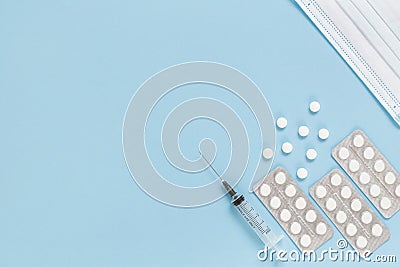 Medical face mask, packaging with pills, expendable syringe for vaccination. Vaccination concept against various infection Stock Photo