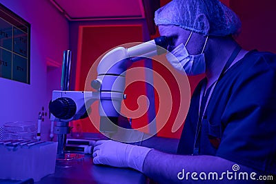 Medical laboratory scientist keeping researches looking in microscope Stock Photo