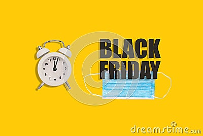 Medical mask, alarm clock and text Black Friday. Safety while shopping due to the coronavirus. Advertising composition, promo. Stock Photo