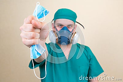 Doctor holds medical mask on the yellow background defocused Stock Photo