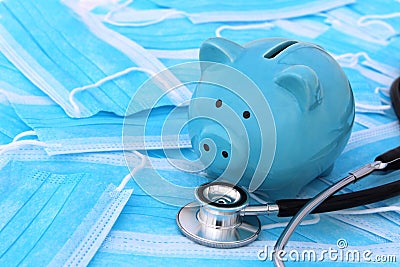 On medical masks lies a stethoscope and a piggy bank. Stock Photo