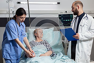 Medical nurse attaching oxymeter on senior woman patient Stock Photo