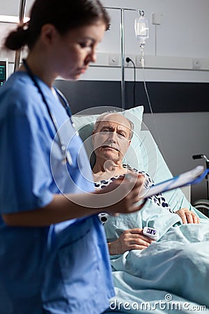 Medical nurse in scrubs taking notest on cliboard Stock Photo