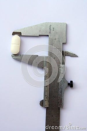 Medical pill in a vernier. Measuring medical pill. Stock Photo