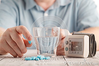 Medical pills against hypertension in hand, equipment for measuring blood pressure Stock Photo