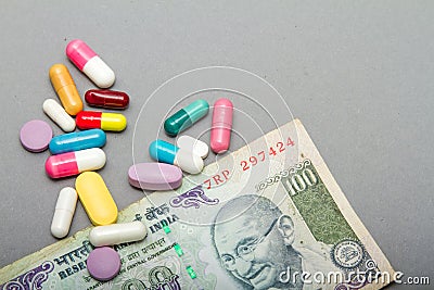 Medical pills in different colors and money. Stock Photo